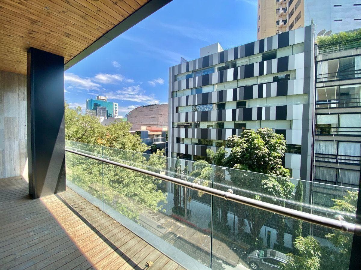 Terraza con duela de madera y vista a edificios entre árboles
