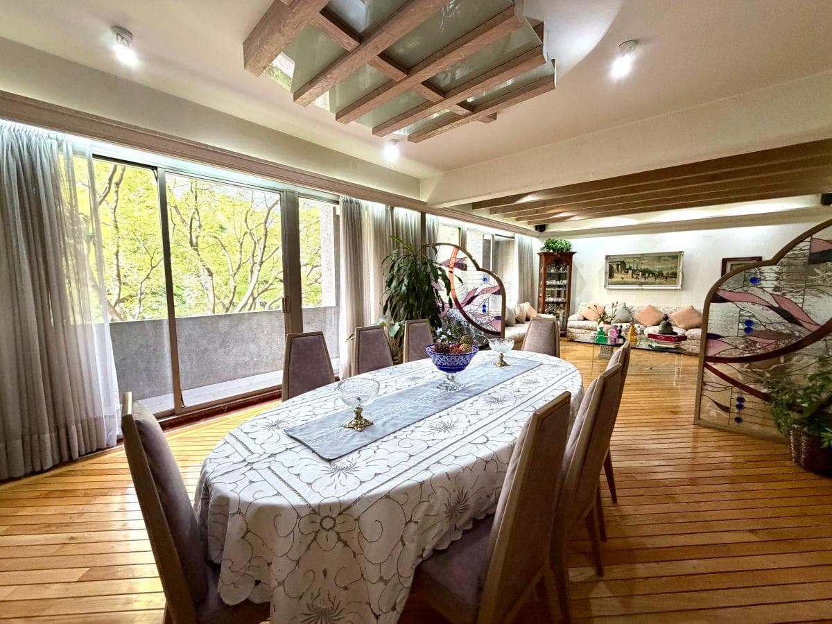 Comedor con vigas de madera y ventanales al bosque