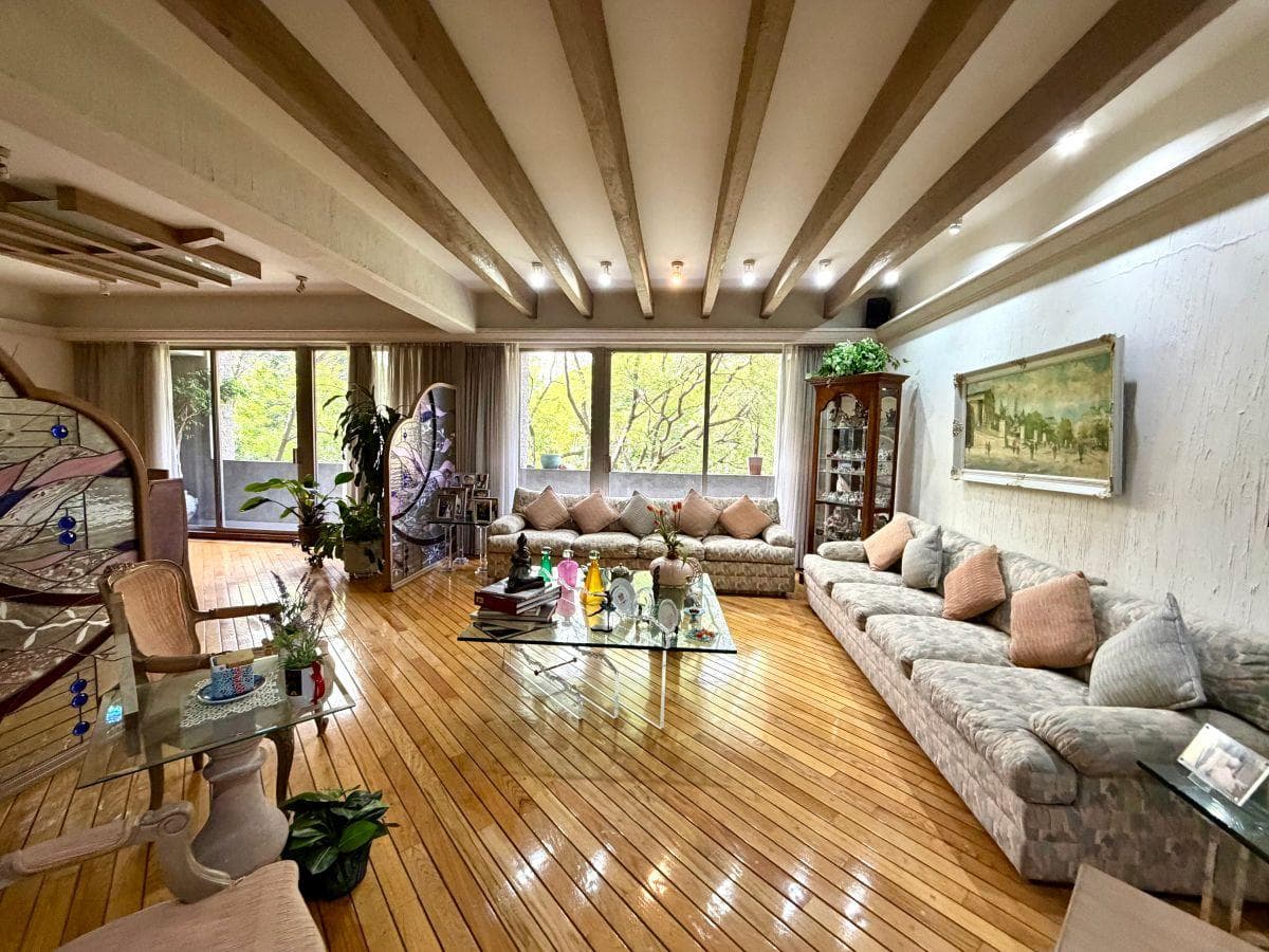 Sala amplia con duela de encino y techo de vigas